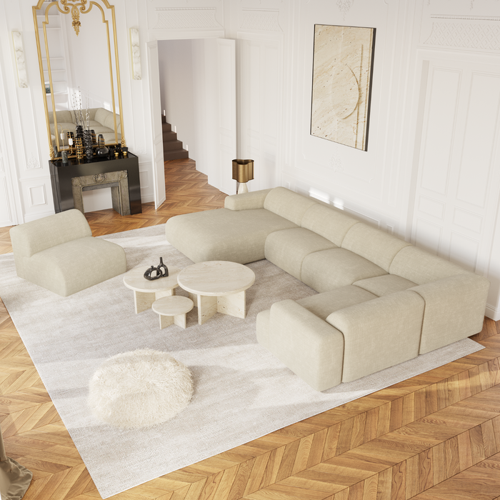 Panoramische sofa links, bekleed met crèmekleurig fluweel met patroon.